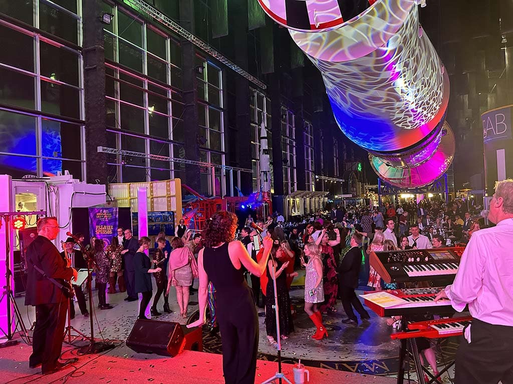 Party of 5 performing before a packed crowd at the U.S. Space & Rocket Center